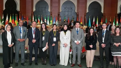 Participants à l’EMC Youth MUN 2026 posant en groupe à Rabat devant des drapeaux internationaux lors d’un événement sur la cybersécurité et l’intelligence artificielle