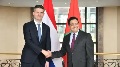 Nasser Bourita et le ministre des Affaires étrangères des Pays-Bas se serrant la main à Rabat devant les drapeaux marocain et néerlandais lors d’une rencontre diplomatique