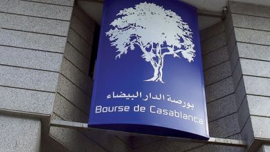 Façade extérieure du bâtiment de la Bourse de Casablanca, avec une enseigne bleue affichant un arbre blanc stylisé et les inscriptions en arabe et en français « Bourse de Casablanca ».