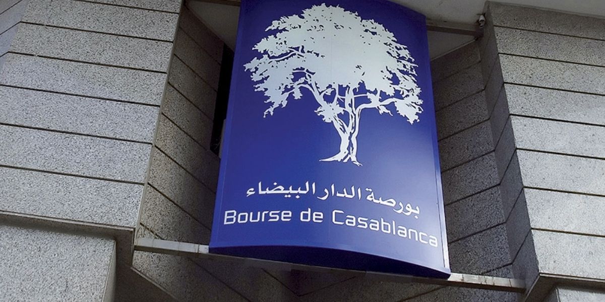 Façade extérieure du bâtiment de la Bourse de Casablanca, avec une enseigne bleue affichant un arbre blanc stylisé et les inscriptions en arabe et en français « Bourse de Casablanca ».