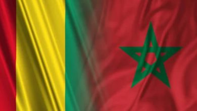 Illustration des drapeaux du Maroc et de la Guinée flottant côte à côte, symbolisant le renforcement des relations diplomatiques et le soutien de Conakry à la souveraineté marocaine sur le Sahara.