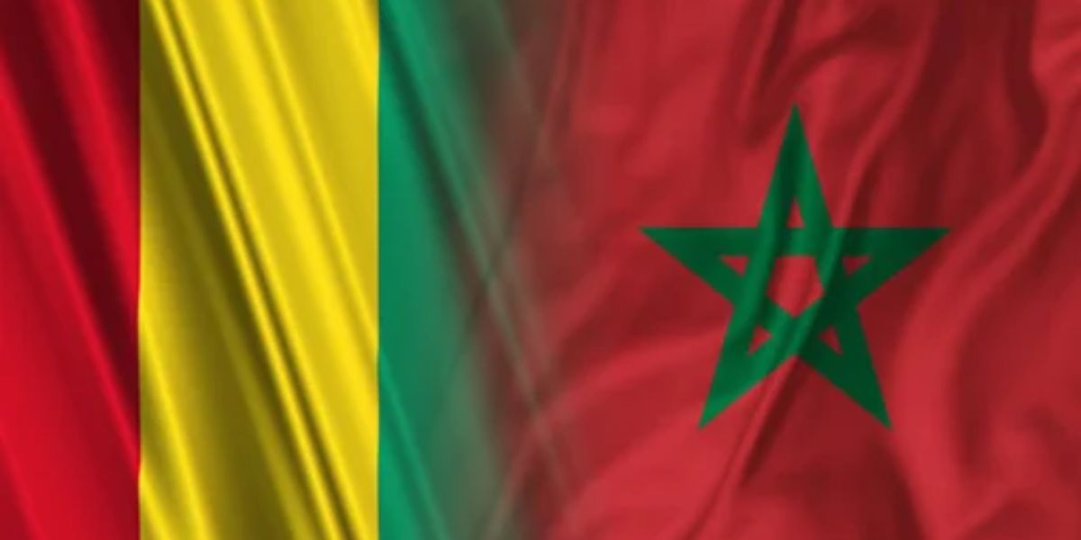 Illustration des drapeaux du Maroc et de la Guinée flottant côte à côte, symbolisant le renforcement des relations diplomatiques et le soutien de Conakry à la souveraineté marocaine sur le Sahara.