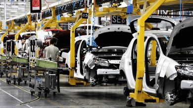 Usine automobile au Maroc avec une chaîne de montage industrielle où plusieurs véhicules en cours d’assemblage sont alignés dans une unité de production moderne, illustrant le développement du secteur automobile marocain et sa montée en puissance industrielle.