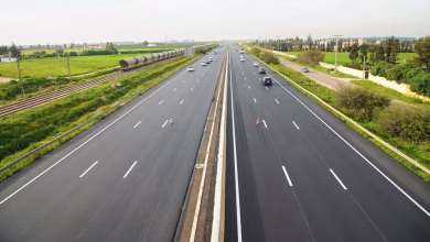 Autoroute marocaine à plusieurs voies traversant une zone rurale, avec circulation fluide de véhicules et paysages agricoles de part et d’autre.