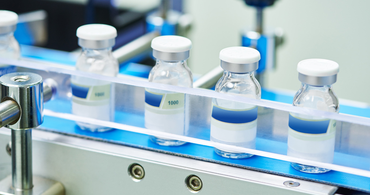 Flacons de médicaments alignés sur une chaîne de production automatisée dans une usine pharmaceutique moderne, illustrant la fabrication industrielle de produits de santé et le développement de l’industrie pharmaceutique.